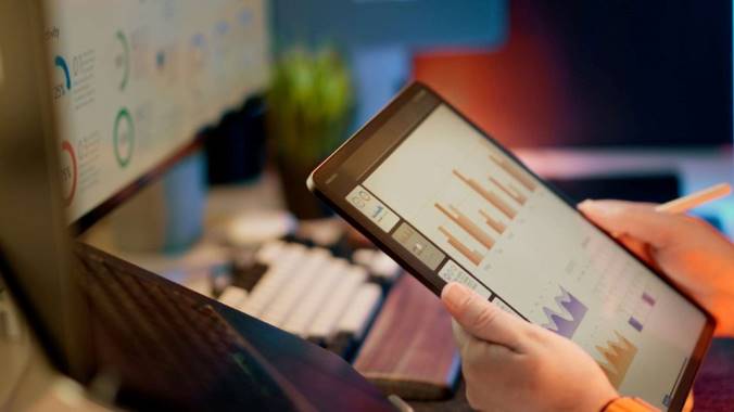Person analyzing financial data graphs on a tablet